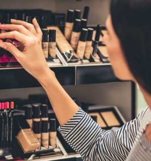 A person shopping for cruelty-free cosmetics with vegan ingredients lists