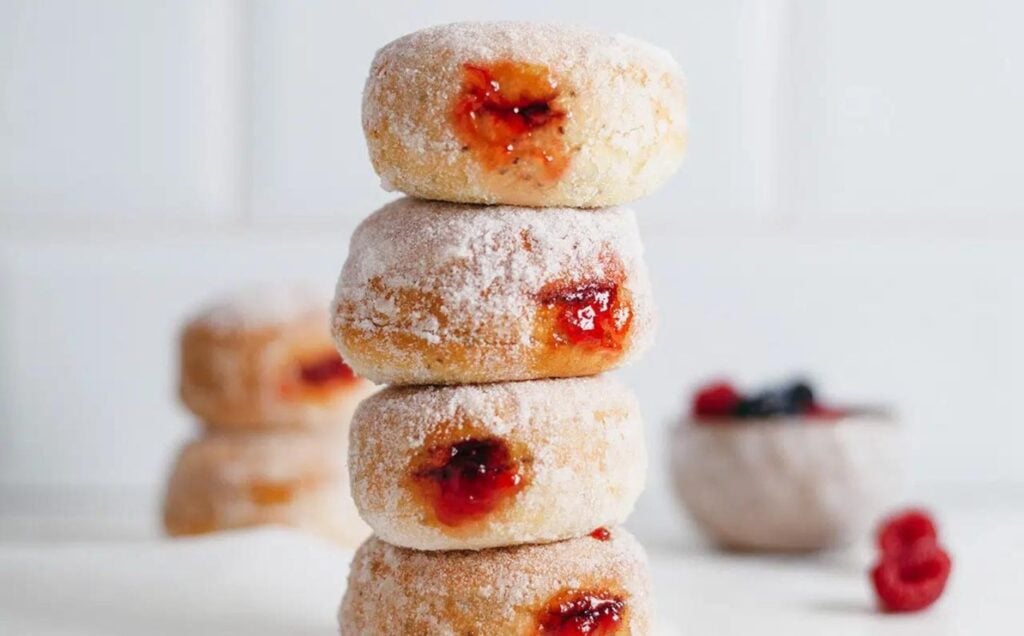 A stack of baked dairy-free donuts filled with sweet vegan jam