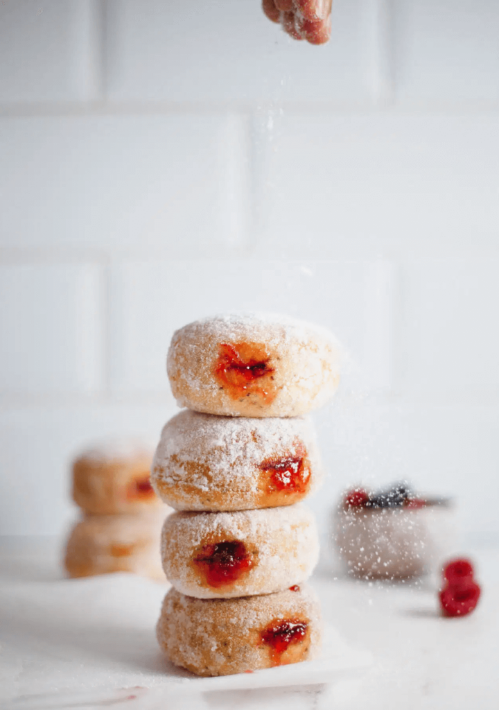 A stack of vegan baked donuts filled with strawberry jam