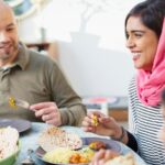 A family sit around a dinner table eating plant-based food