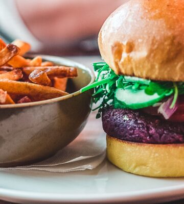 A vegan meat burger and chips