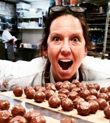 Chocolatier Ruth Hinks poses in a kitchen with chocolate