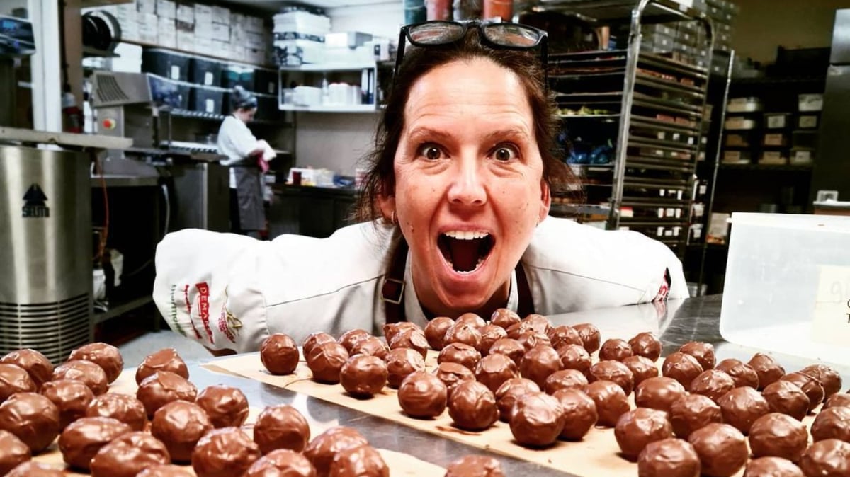 Chocolatier Ruth Hinks poses in a kitchen with chocolate