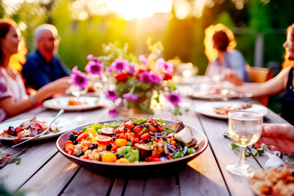 A plate of nutrient-rich vegan food on a table where people are sitting and eating