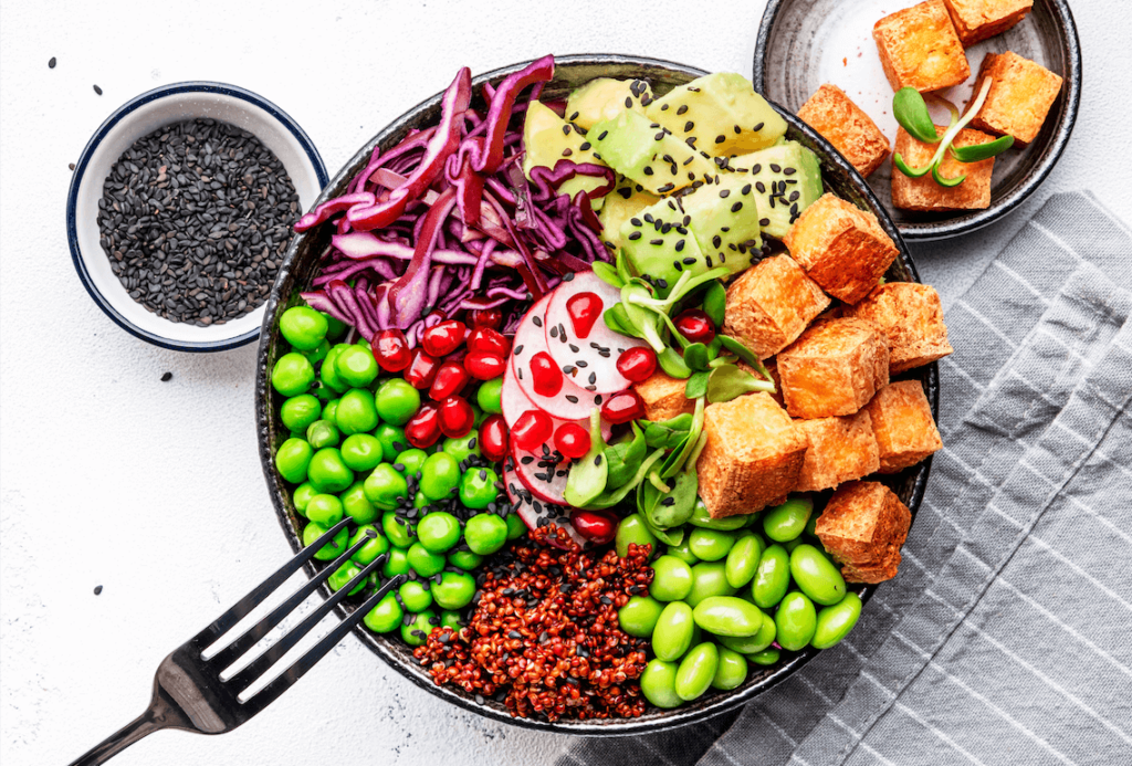 A vegan bowl containing tofu, edamame beans, cabbage, and other plant-based foods, which can be part of a healthy diet