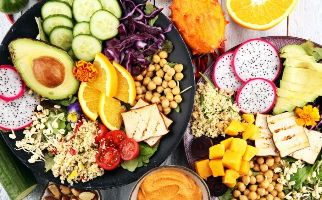 A spread of plant foods including cucumber, avocado and chickpeas, which can be part of a healthy vegan diet