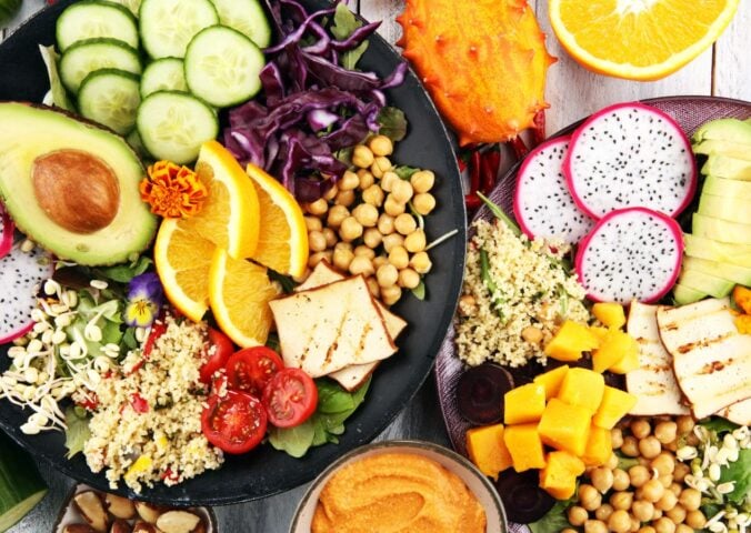A spread of plant foods including cucumber, avocado and chickpeas, which can be part of a healthy vegan diet