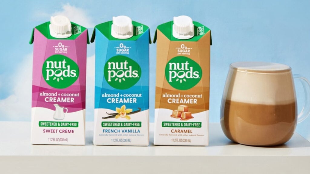 Cartons of vegan-friendly nutpods beside a hot beverage