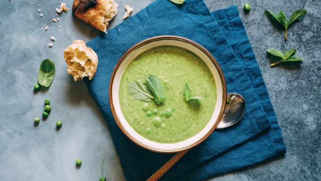 Bowl of pea and mint soup with bread