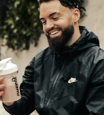 Man sits with protein shaker