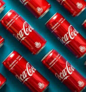 A selection of cans of vegan fizzy drink Coca Cola