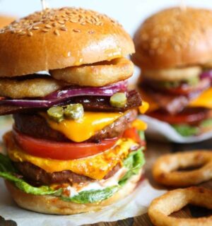 Viva Vegan Recipe Club's meat-free mega burger stacked with dairy-free cheese, salad, and onion rings