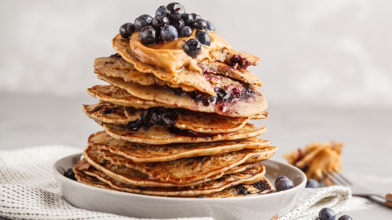 a stack vegan blueberry pancakes with peanut butter and syrup