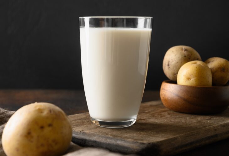 Vegan potato milk and potato on brown background