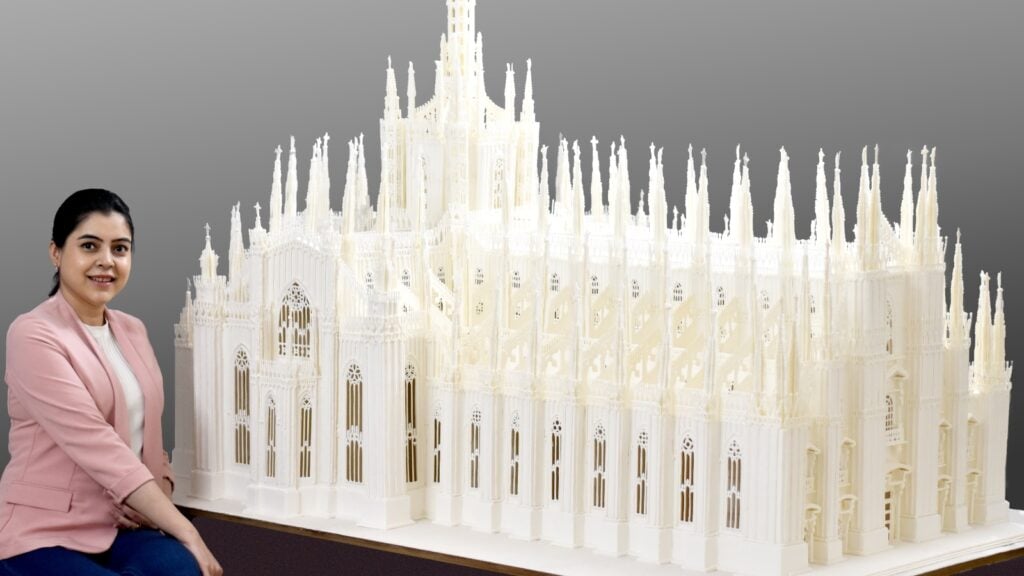 Indian baker Prachi Deb pictured next to her royal icing structure of the Milan Cathedral