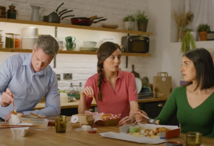 screenshot of tv advert in which two women and one man are sat down eating a meal