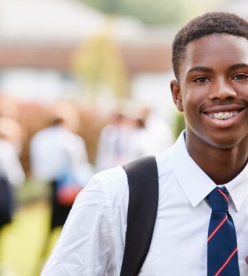 A school boy in uniform wearing a tie outside