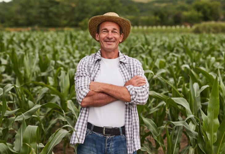 A farmer stands in a field of crops