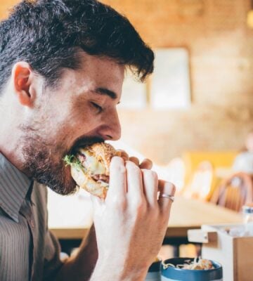 Man eating meat burger
