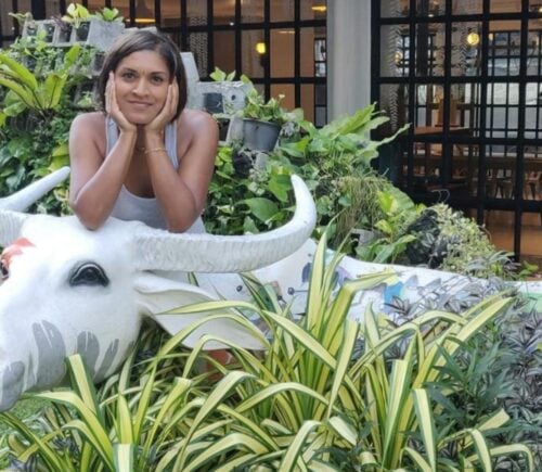 Mitali Deypurkaystha smiling on a cow statue