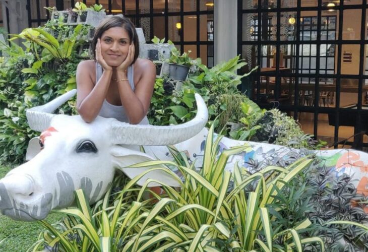 Mitali Deypurkaystha smiling on a cow statue