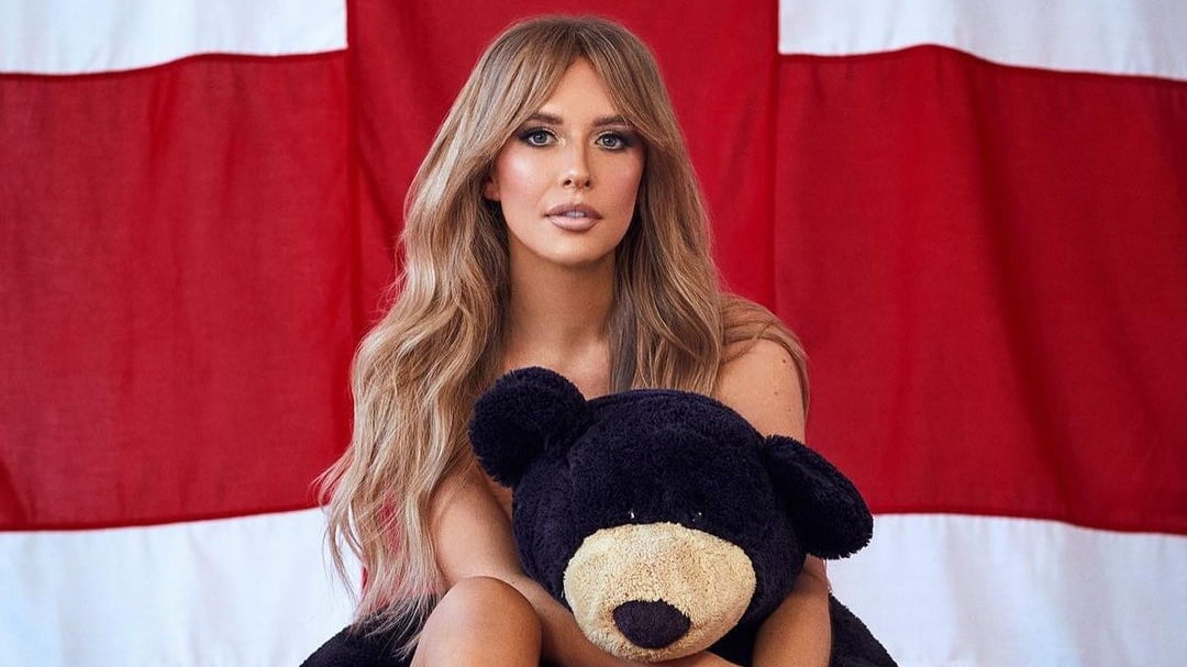 Faye Winter poses naked with a teddy bear in front of a union jack