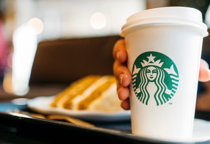 Person holding a Starbucks coffee cup