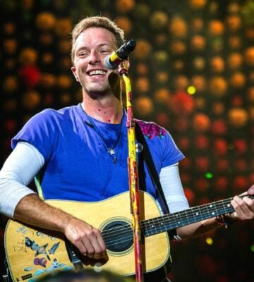 Chris Martin performs with guitar on stage