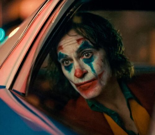 Joaquin Phoenix looking out of a car as the Joker
