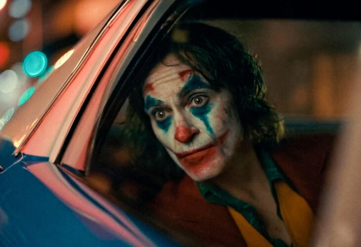 Joaquin Phoenix looking out of a car as the Joker