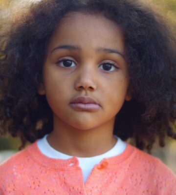 close up of a young girl looking sad and serious