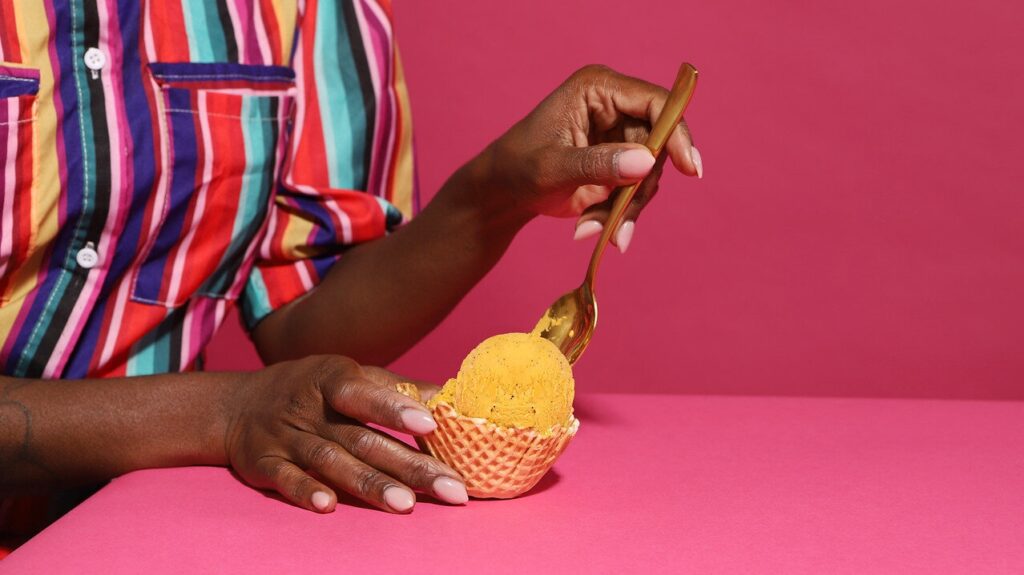 A woman scoops ice cream with a spoon