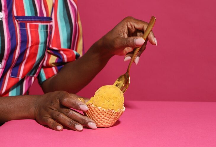 A woman scoops ice cream with a spoon