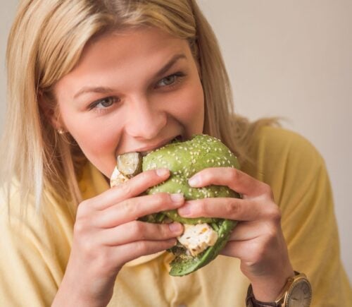 Woman eating vegan burger in restaurant