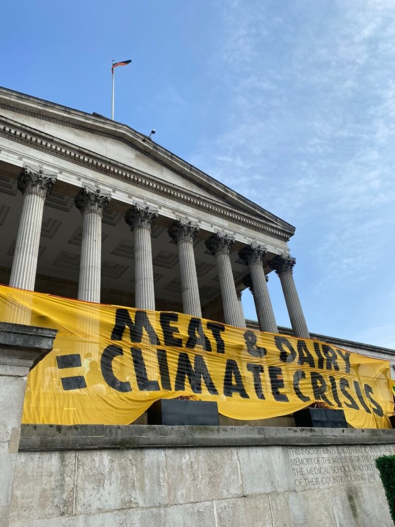 A banner that says "meat and dairy climate crisis" outside a university