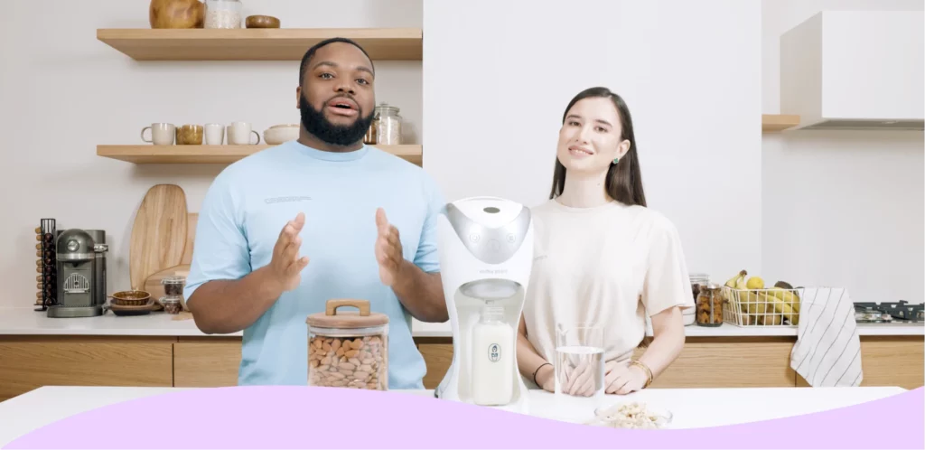 Two people talking in front of a Milky Plant appliance