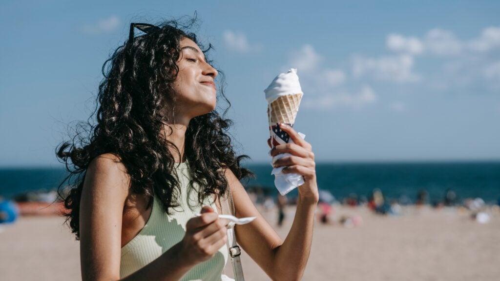 Woman eating ice cream on the beach