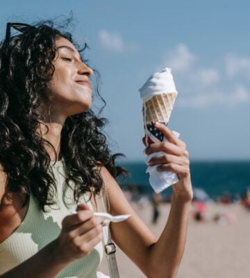 Woman eating ice cream on the beach