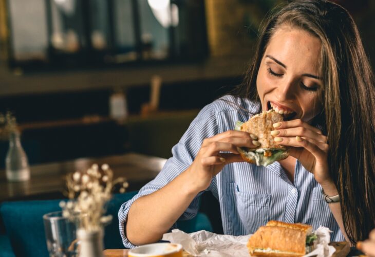 A woman eating a sandwich at a restaurant