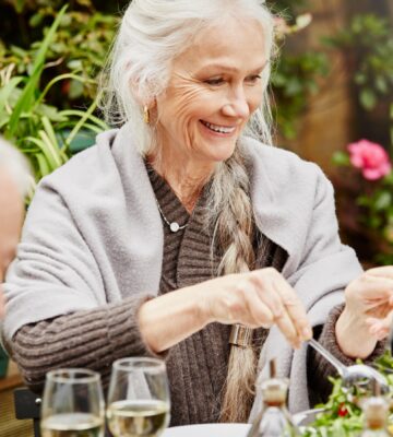 woman serves salad in the garden