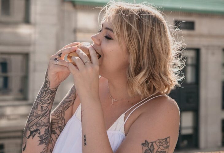 woman on a rooftop eating a burger