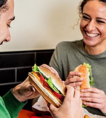 two people eating burger king burgers and smiling