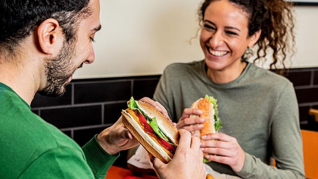 two people eating burger king burgers and smiling