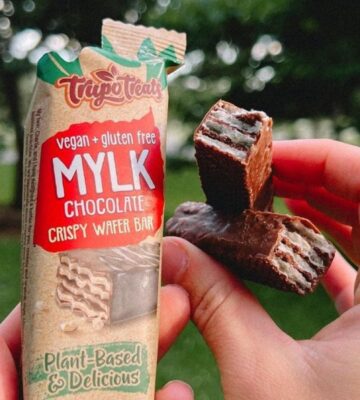 A person's hands holding a vegan, gluten-free chocolate wafer bar by Trupo Treats