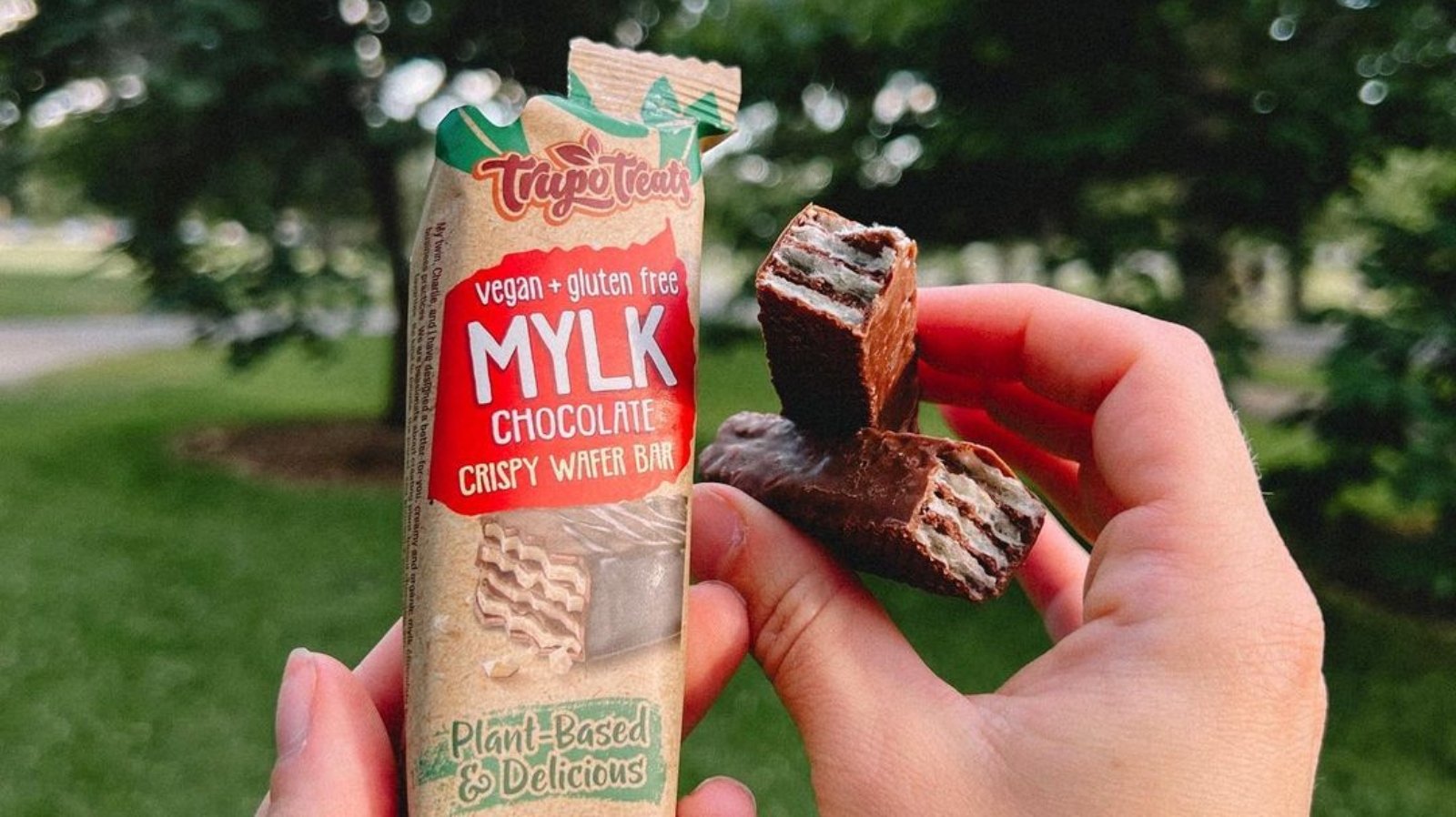 A person's hands holding a vegan, gluten-free chocolate wafer bar by Trupo Treats