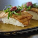 King oyster mushroom vegan sushi that has been scored to resemble real fish