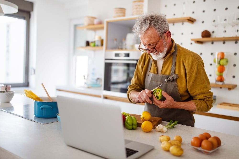 Older man preparing plant-based food in his kitchen