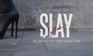 Black high heels on the pavement next to the words SLAY THE FILM THAT GETS UNDER FASHION'S SKIN