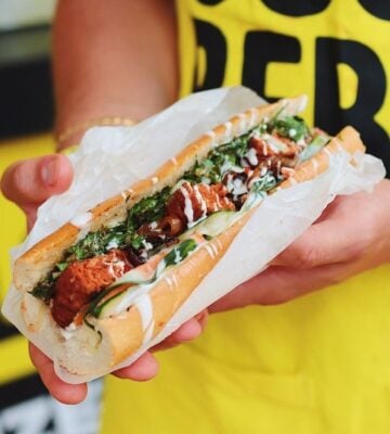 A person holding a hot dog by Heura Foods