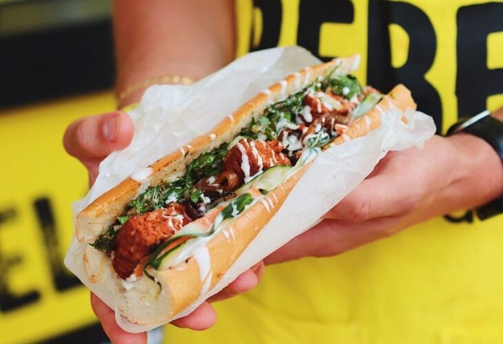 A person holding a hot dog by Heura Foods